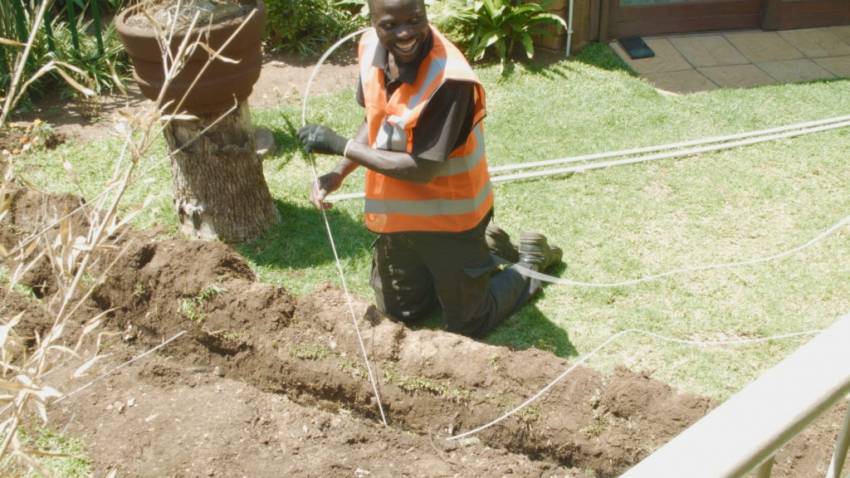 Installation de la fibre dans un foyer sud-africain par un employé de MetroFibre Networx.